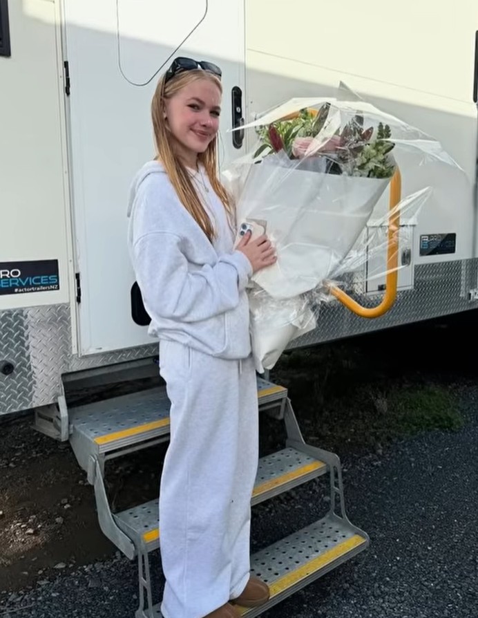 Freya Skye outside her actor trailer holding flowers